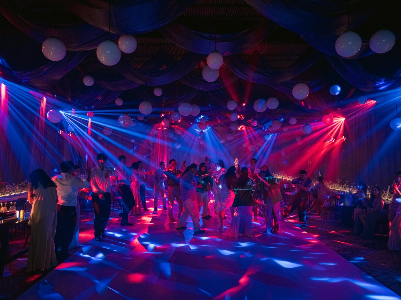 Guests dancing under colorful moving-head lights