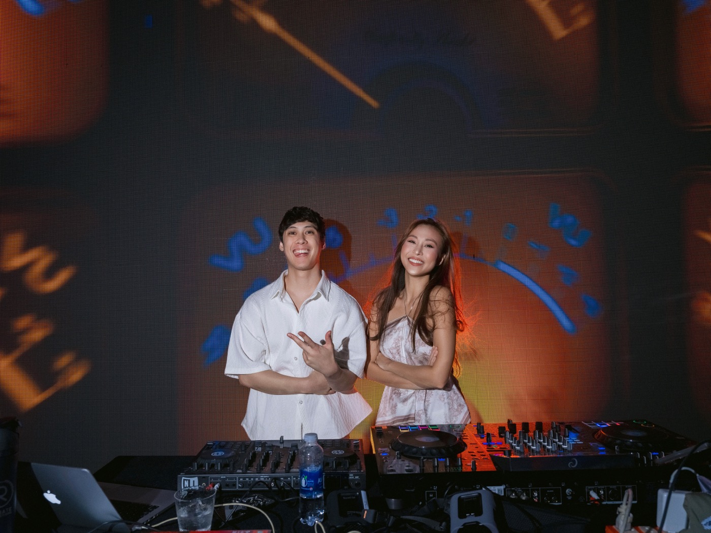 DJ posing with a guest behind the booth